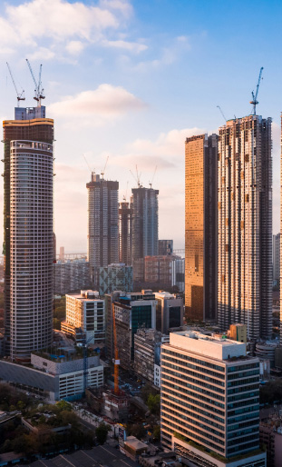 Moderne Skyline mit Hochhäusern bei Sonnenuntergang – Symbol für Fortschritt, Präzision und Vertrauen von KFZ-Sachverständiger Baban Ali in München